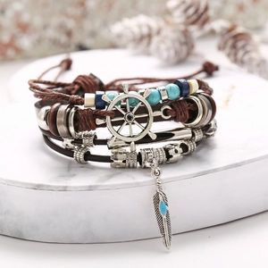 Detail of multi-layer leather bracelet with turquoise beads and silver helm charms