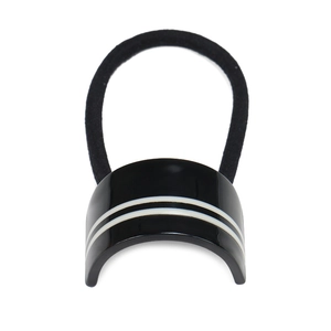 Detailed view of black acetate hair tie featuring a curved design with two white stripes