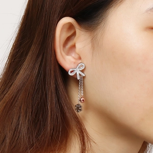 Silver bow stud earring with rhinestones and dangling snowflake charms on female model