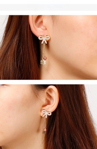 Close-up of rose gold bow earrings with white cubic zirconia and snowflake pendants