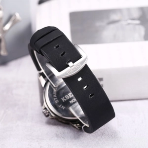 Detail of black silicone watch strap with stainless steel buckle and brand engraving
