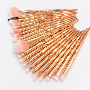 Flat lay of 20-piece makeup brush set with diamond cut handles and pink gradient bristles