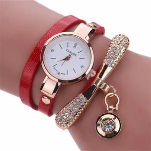 Detail of red snake-pattern leather wrap strap and gold crystal watch dial for women
