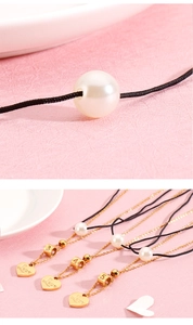 Detailed view of layered pearl necklaces with gold heart charms and number pendants
