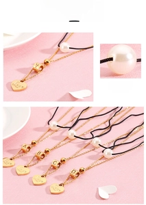 Macro detail of gold-layered heart necklace with Love engraving and faux pearl decor