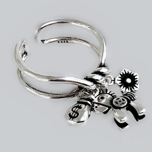 Macro shot of S925 sterling silver ring showing money bag, horse, and flower charms