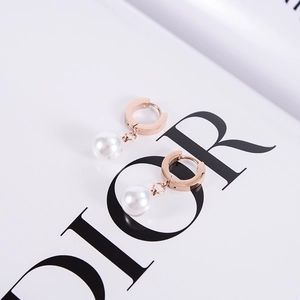 Élégantes créoles plaquées or rose 18K avec perles blanches sur fond de magazine chic