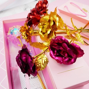 Detailed macro shot of 24K colorful gold foil roses and textured petals in a pink gift box