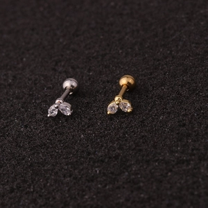 Macro detail of leaf-shaped stainless steel cartilage studs with cubic zirconia gems
