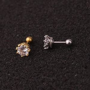 Macro shot of gold and silver crown stud earrings with sparkling cubic zirconia stones