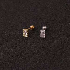 Macro shot of gold and silver crown stud earrings with rectangular zircon and beaded edges