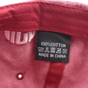 Dettaglio macro dell'etichetta e ricamo su un cappellino da baseball in cotone bordeaux