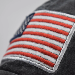 Dettaglio del ricamo della bandiera americana su un cappello da baseball in cotone lavato