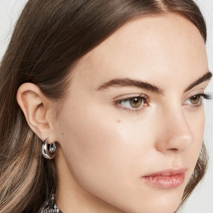 Poliertes silbernes Chunky-Creole-Ohrring an einem Model im minimalistischen Stil