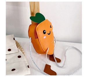 Close-up of cute carrot shaped crossbody bag with smiling face and green leaves
