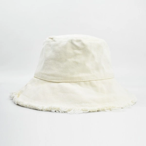 Close-up of distressed frayed edge detail on a cream-white canvas bucket hat