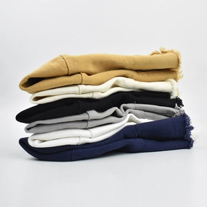 Frayed edge canvas bucket hats in various colors stacked against a neutral grey background