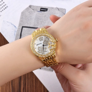 Women's gold quartz watch with butterfly dial and rhinestone bezel on wrist