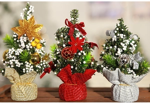 Three 20cm mini Christmas trees in gold, red and silver on a rustic wooden table