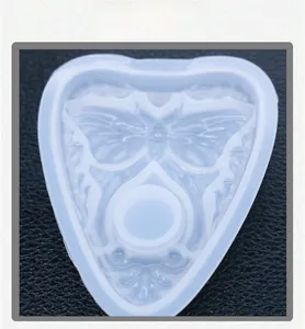Macro detail of a heart-shaped silicone mold with intricate butterfly and floral patterns