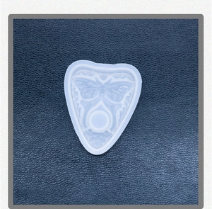 Detailed view of a planchette-shaped silicone mold featuring a butterfly relief design