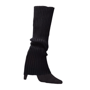 Close-up of black ribbed knit leg warmers styled with elegant black pointed high heels