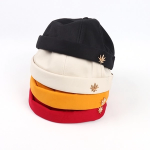 Docker brimless cap in four colors featuring a gold leaf emblem for hip-hop style