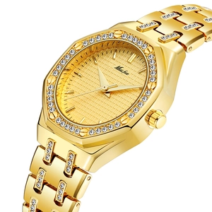 Close-up of gold ladies watch with crystal hexagonal bezel and polished mesh dial