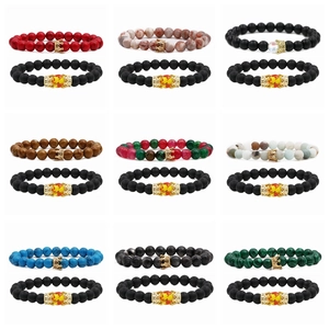 Close-up showing colorful natural stone beaded bracelets with golden crown and lion head charms