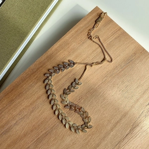 Macro shot of S925 sterling silver gold leaf pendant on a natural wooden background
