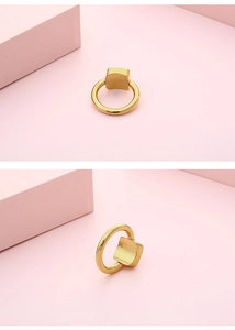 Detailed view of a gold-plated square geometric ring with a minimalist polished finish