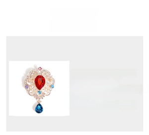 Detailed view of baroque brooch with colorful crystals and blue teardrop pendant