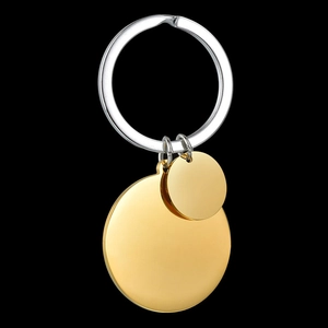 Macro detail of minimalist dual-tone round metal keychains on a black background