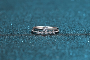 Macro shot of 925 silver moissanite rings set with round main stone on dark blue background