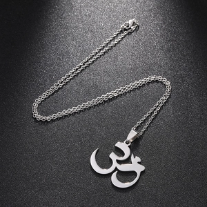 Silver stainless steel Om pendant necklace with O-chain on a dark textured background