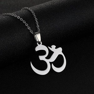 Close-up of a silver stainless steel Om pendant necklace on a black textured background
