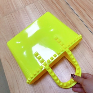 Detailed macro view of vibrant neon green jelly bag featuring square studded accents