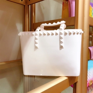 Detail shot of white jelly tote bag featuring signature pyramid rockstuds and top handles