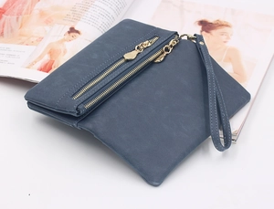 Close-up of a matte dark blue long wallet featuring dual gold zippers and wrist strap