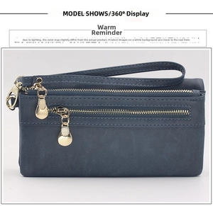 Detail view of a navy blue matte wallet featuring double gold zippers and wrist strap