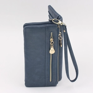 Detail of dark blue matte leather wallet with gold zipper and matching wrist strap