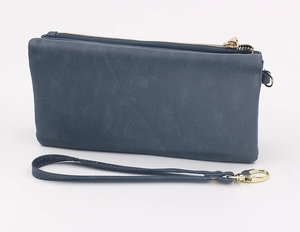 Close-up of matte blue-grey long wallet with gold zipper and detachable wrist strap