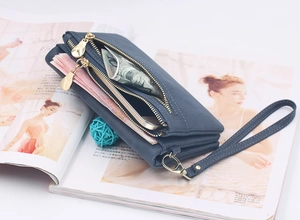 Detail of dark blue frosted leather wallet with multi-zipper layers on a magazine