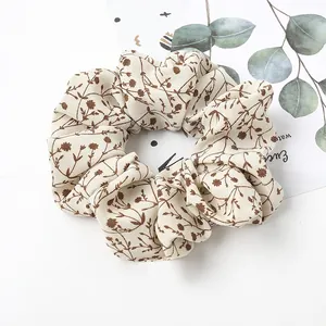 Floral scrunchie detail in cream fabric with brown botanical prints and soft texture