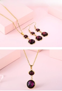 Detail view of gold-plated necklace and earrings set with purple faceted gemstones