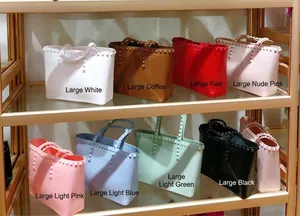 Detailed close-up of large studded jelly tote bags in eight assorted vibrant colors