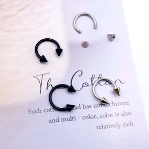 Detail shot of stainless steel horseshoe rings with spiked ends in black and silver