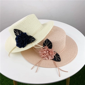 Cappelli di paglia estivi a tesa larga con decorazioni floreali per la spiaggia e i viaggi