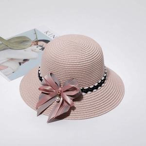 Pink straw sun hat for girls with bow ribbon and pearl accent on white background