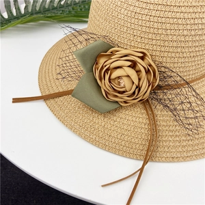 Straw sun hat for women with brown flower decoration, green ribbon and black mesh veil